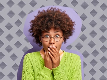 Woman looking surprised and covering her mouth with her hands.